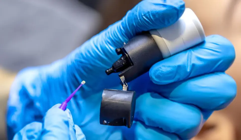 Gloved hands holding dental instruments
