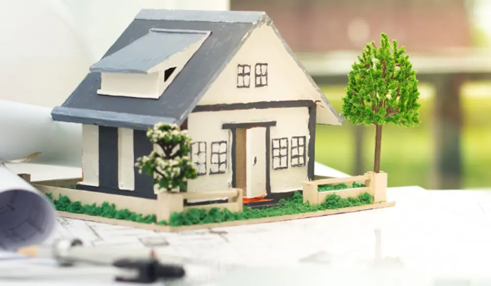 Model house on top of building plans